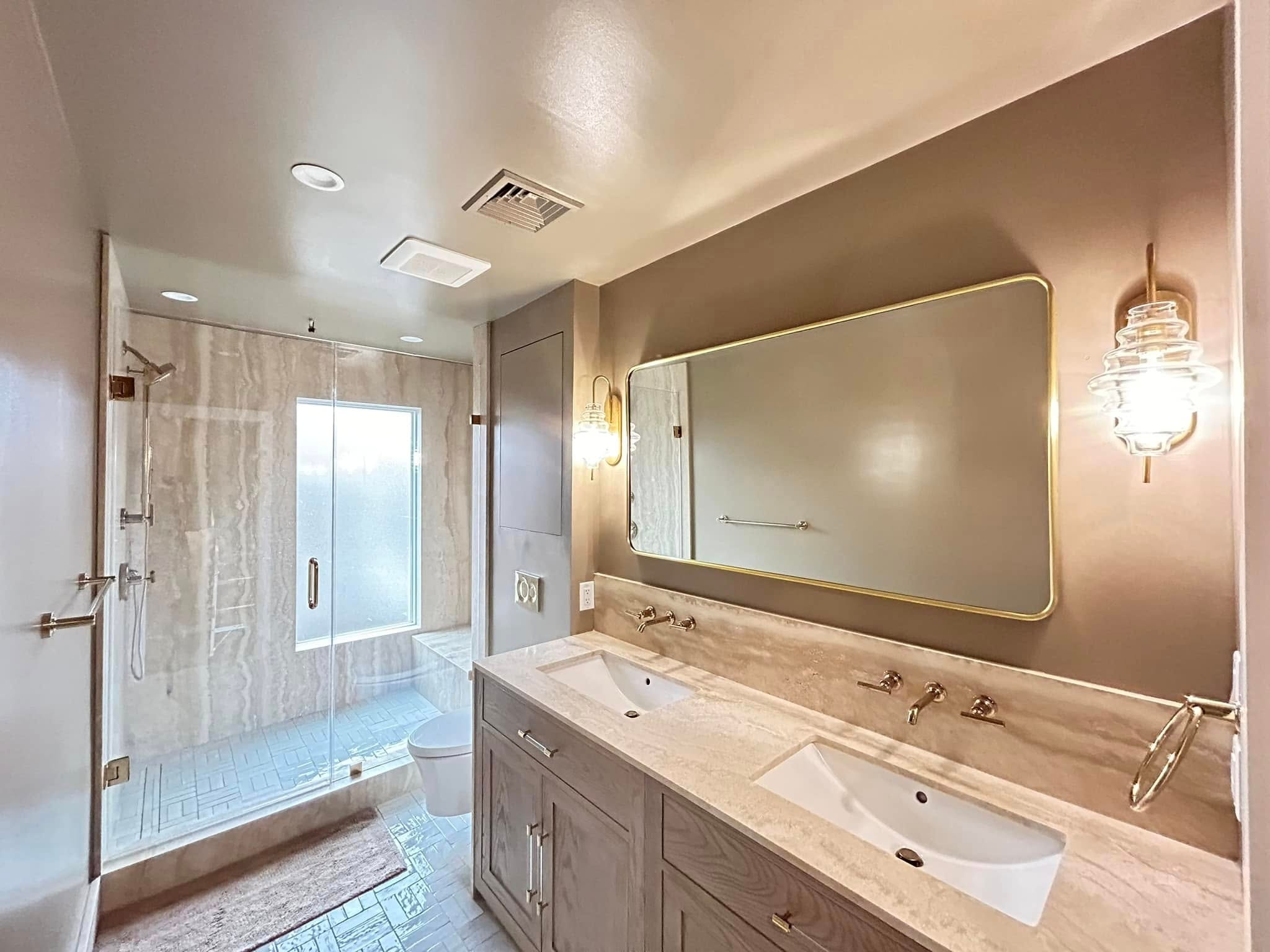 Master bathroom with double vanity, marble countertop and glass shower enclosure