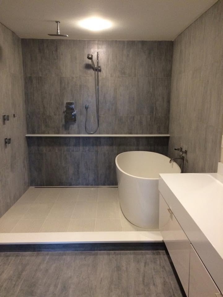 Modern wet room with freestanding tub, rain shower and large format tile
