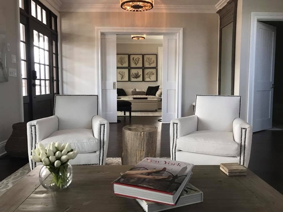 Sitting room with nailhead armchairs, live-edge stump table and French doors