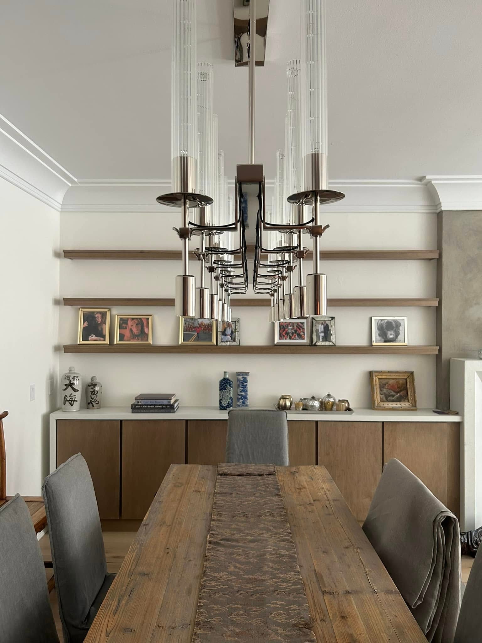 Dining room with reclaimed wood table, floating shelves and sculptural chandelier